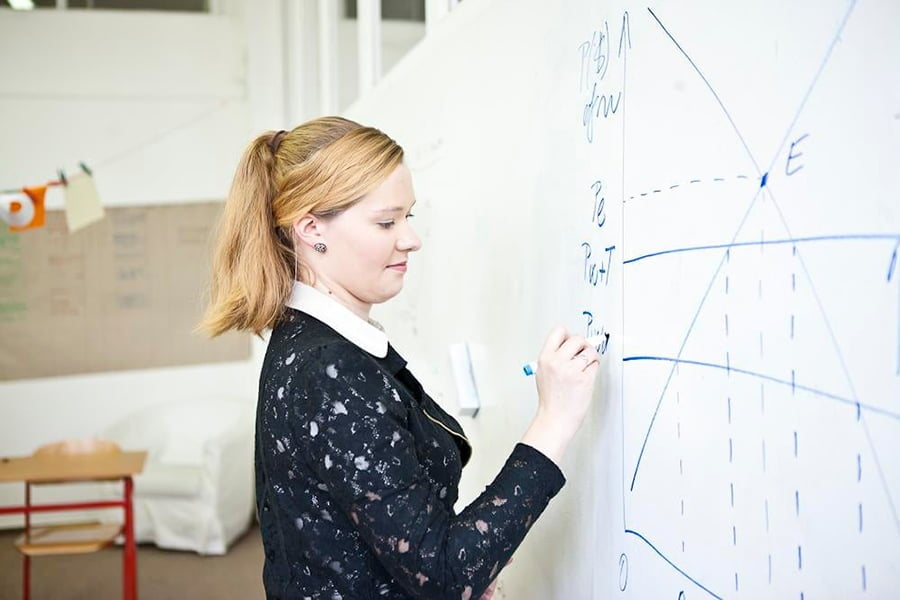 woman writing on a Smarter Surfaces Smart Whiteboard Paint wall